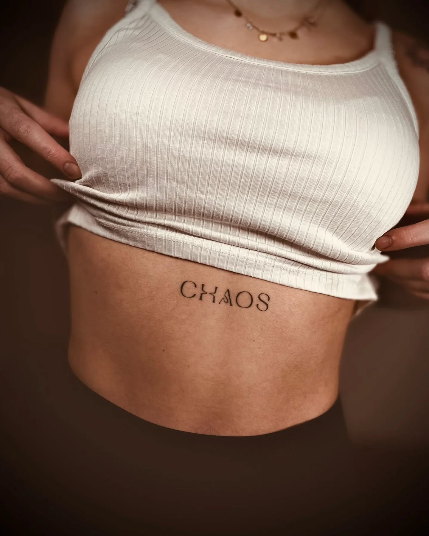 Tatuaż napis chaos na brzuchu — lettering, Kacper, Kraków