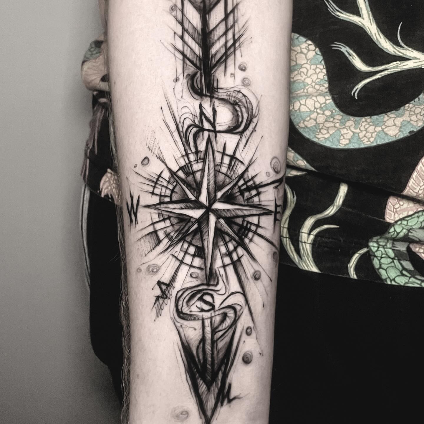 Tatuaż kompasu i strzały na przedramieniu — blackwork, Buka, Kraków