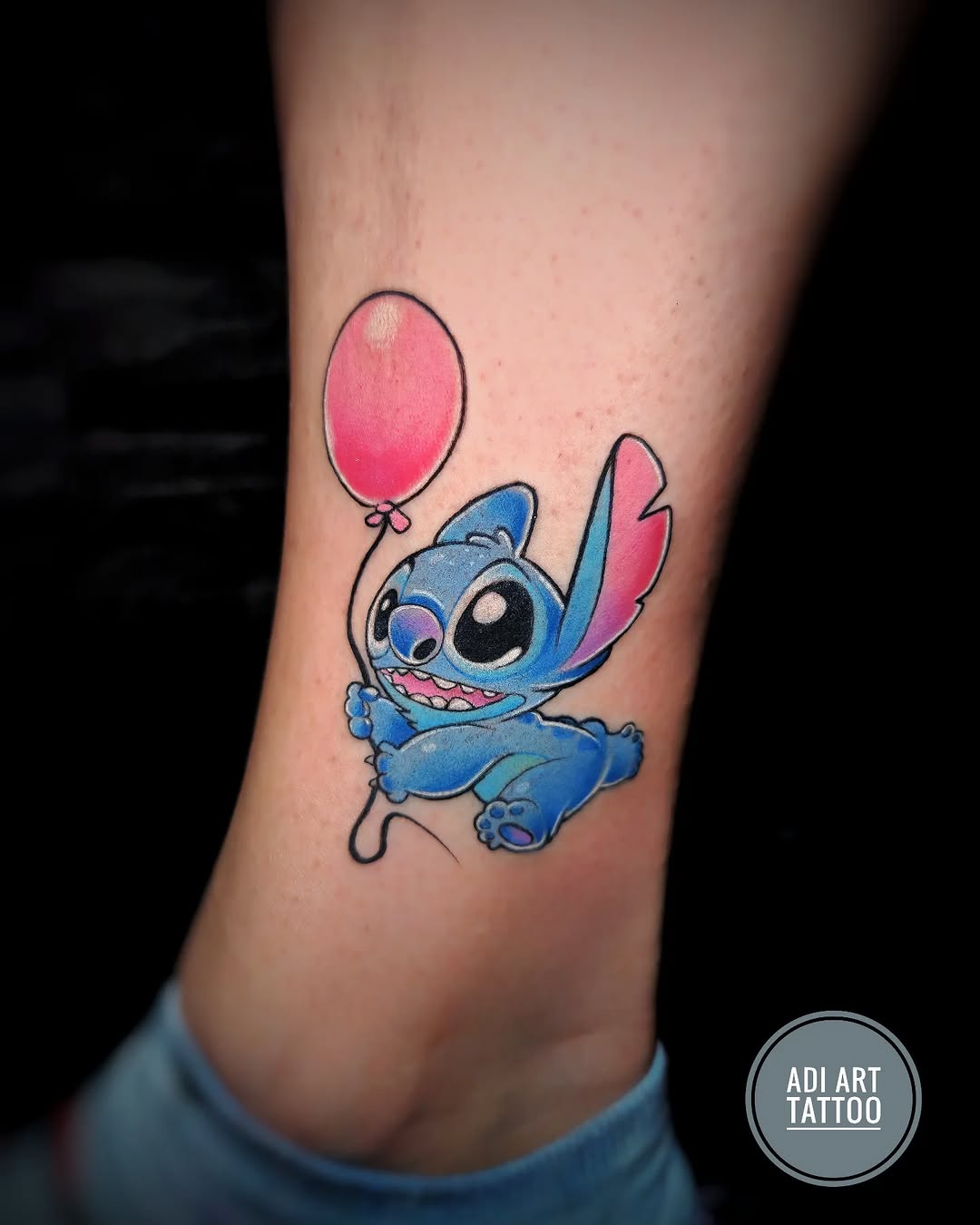 Tatuaż: Stitch · postać z kreskówki. Wykonał Adi (Kraków). Otwórz zdjęcie w profilu.