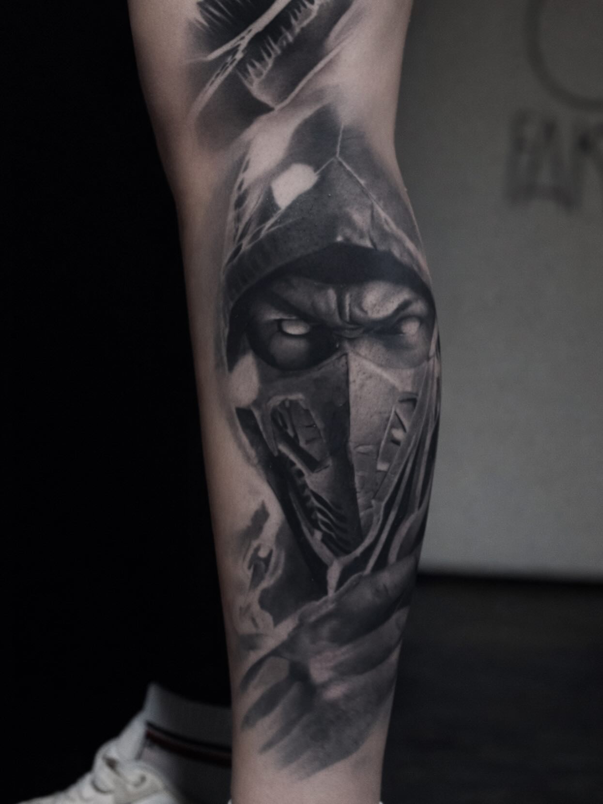 Tatuaż postaci ninja z maską i zwierzęciem na łydce — realizm, blackwork, mace, Kraków